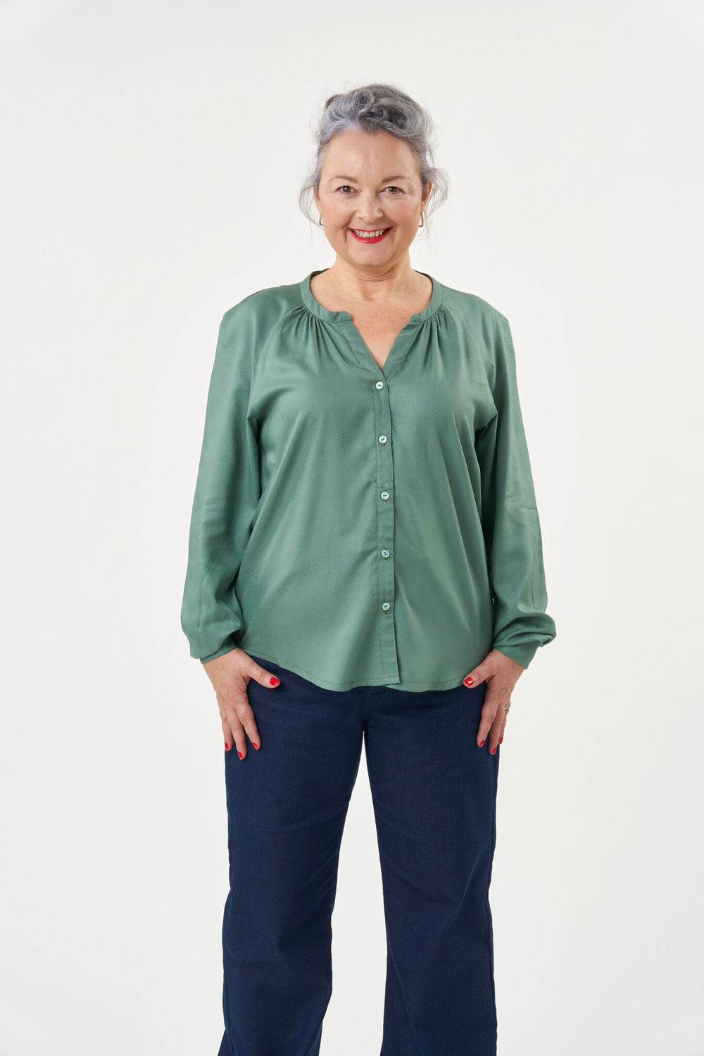Woman wearing the Zadie Blouse sewing pattern from Sew Over It on The Fold Line. A blouse pattern made in chiffon, georgette, crepe or fine rayon fabrics, featuring a loose fit, button front closure, short band collar and long gathered sleeves with button