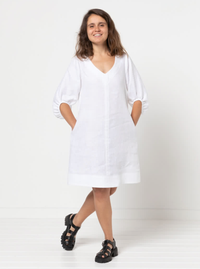 Woman wearing the Zalia Woven Dress sewing pattern from Style Arc on The Fold Line. A dress pattern made in lightweight linen, cotton, or crepe fabric, featuring a slight A-line shape, V neckline, topstitched front and back seams, on-trend balloon sleeves