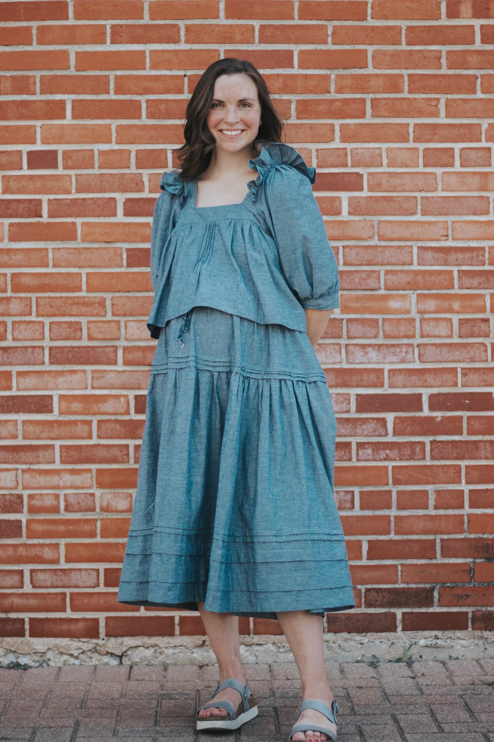 Woman wearing the Zamora Skirt sewing pattern from Madswick on The Fold Line. A skirt pattern made in linen, cotton, or tencel fabrics, featuring an elasticated waistband, two gathered tiers, and midi length.