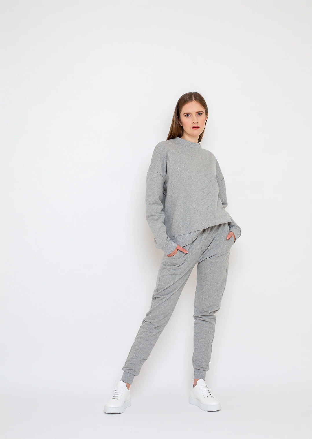 Woman wearing the Zoe Sweatpants sewing pattern from Bara Studio on The Fold Line. A sweatpants pattern made in medium-weight stretch fabrics such as sweat or French terry fabrics, featuring in-seam pockets, gently tapered legs, plus ribbing at the waistb