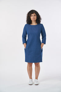 Woman wearing the Zoe Dress sewing pattern from Sew Over It on The Fold Line. A shift dress pattern made in cotton, denim, triple crepe, or wool suiting fabric, featuring princess seams, french darts, darts at the back neckline, an invisible zip, and pock