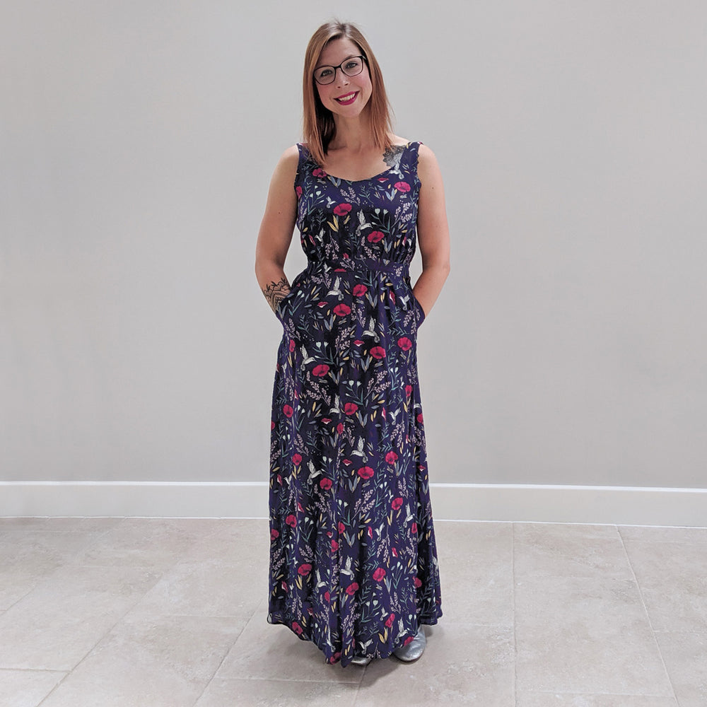 Woman wearing the Rosalee Dress sewing pattern by Experimental Space. A sleeveless dress pattern made in rayon, viscose, crepe, cotton lawn or satin and silk fabrics, featuring a maxi length, deep back and a pretty cutout on the lower back, scoop neckline