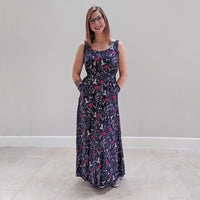 Woman wearing the Rosalee Dress sewing pattern by Experimental Space. A sleeveless dress pattern made in rayon, viscose, crepe, cotton lawn or satin and silk fabrics, featuring a maxi length, deep back and a pretty cutout on the lower back, scoop neckline