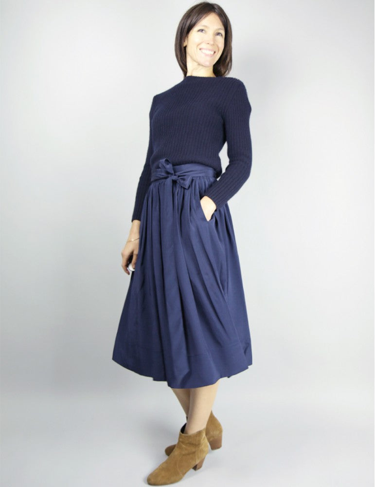 Woman wearing the Arpege Skirt sewing pattern by Atelier Scammit. A full skirt pattern made in very light to light weight batiste, chambray or double gauze fabrics, featuring a back button closure, button and loop fastenings and a long tie belt.