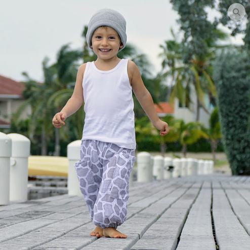 Child wearing the Child/Baby Boho Harems sewing pattern from Elemeno Patterns on The Fold Line. A harem pants/trousers pattern made in gauze or linen fabrics, featuring an elasticated waist and ankles, very roomy fit, and deep patch pockets.