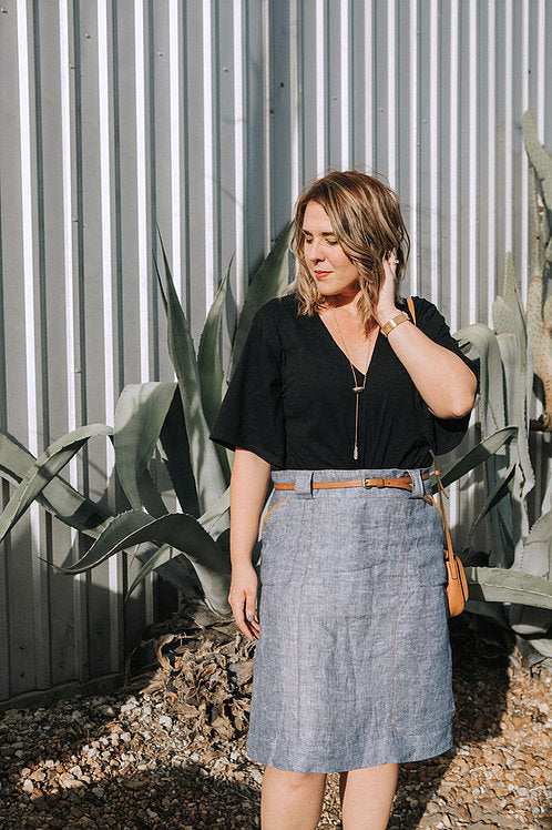 Woman wearing the Stella Skirt sewing pattern from Sew To Grow on The Fold Line. A skirt pattern made in linen, corduroy or denim fabrics, featuring topstitched patch pockets, chunky belt loops, deep hem, invisible side zip closure and knee length hem.