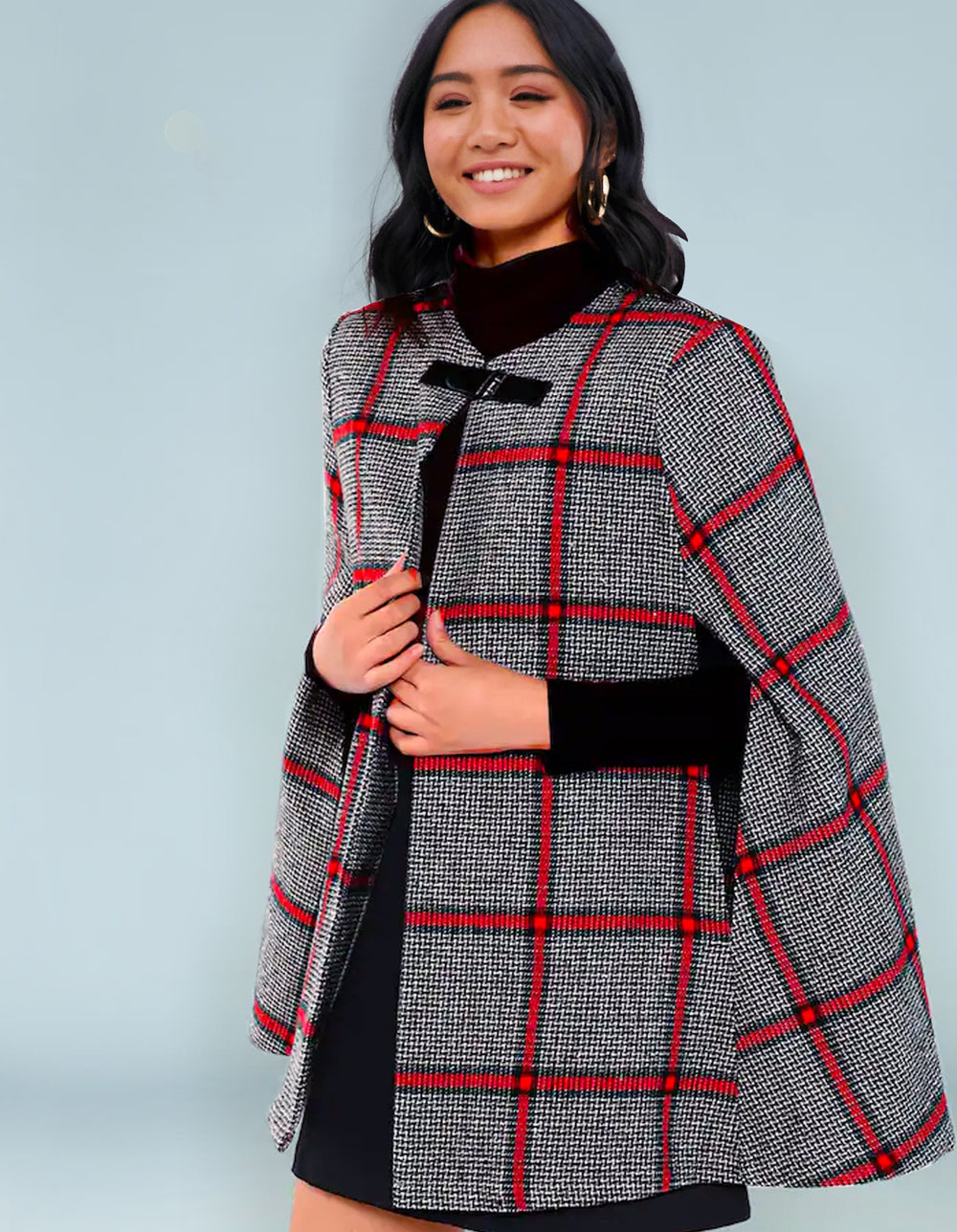 Woman wearing the Caribou Cape sewing pattern from Our Lady of Leisure on The Fold Line. A cape pattern made in boiled wool, felted wool, tweed, flannel or “Bonded” boucle fabrics, featuring a frog clasp closure, non-lined, round neck and front slits for 