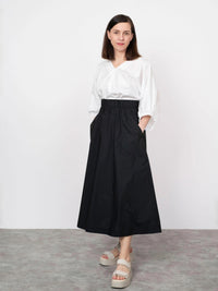 Woman wearing the Elastic Waist Maxi Skirt sewing pattern from The Assembly Line on The Fold Line. A skirt pattern made in cotton poplin, denim, wool, faux leather or cotton twill fabrics, featuring an elasticated waistband, relaxed fit, large patch pocke