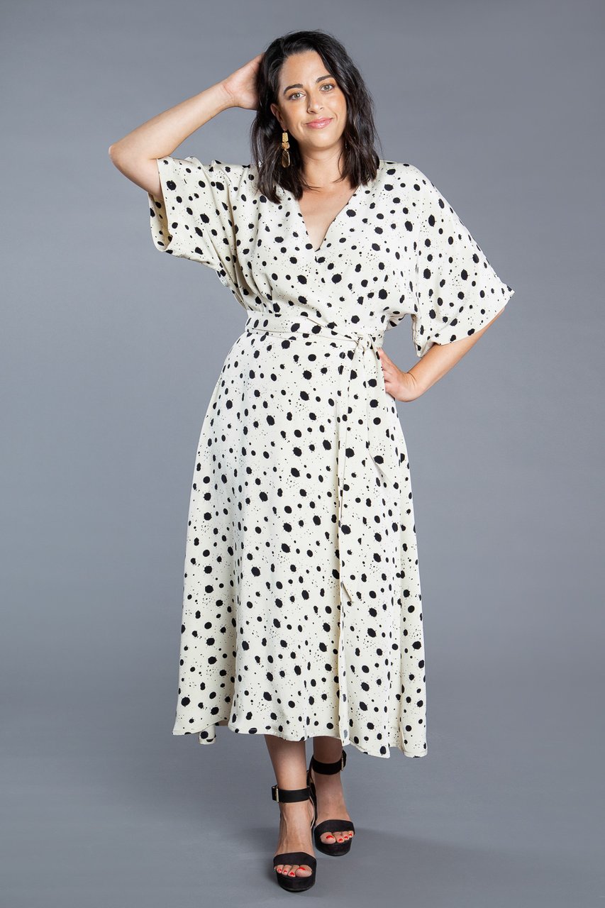 Woman wearing the Elodie Wrap Dress sewing pattern by Closet Core Patterns. A wrap dress pattern made in cotton poplin, linen, batiste or chambray fabric featuring a softly flowing bodice, dolman style sleeves, V-neck and waist tie.