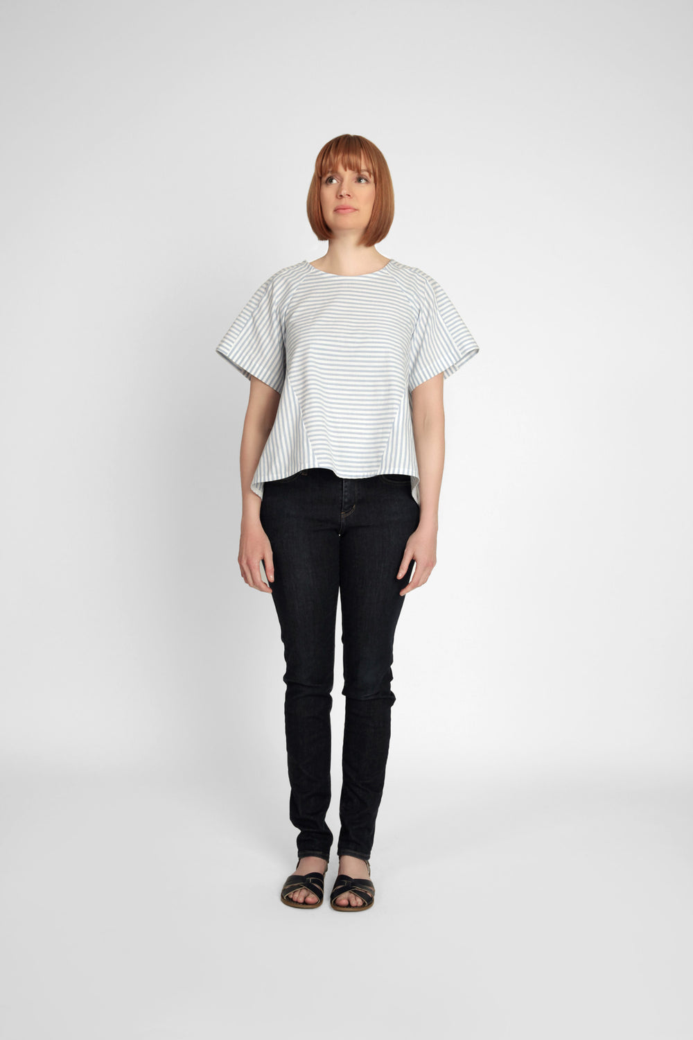 Woman wearing the Collins Top pattern from In the Folds on The Fold Line. A top pattern made in linen, linen blends, cotton, gauze, chambray, sateen, crepe de chine or viscose fabrics, featuring a loose-fitting trapeze-shape, round neck, high-low hem, cen
