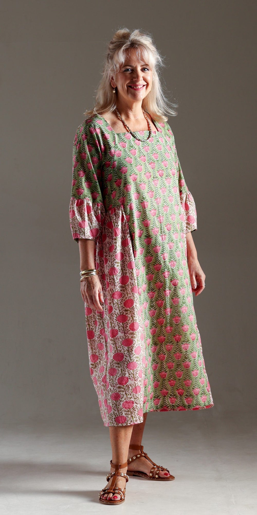 Woman wearing the Mahal Dress sewing pattern from Sew Different on The Fold Line. A dress pattern made in lightweight cotton, viscose, rayon, and lightweight linen fabrics, featuring a midi length, pull-on style, relaxed fit, gathered side panels, square 