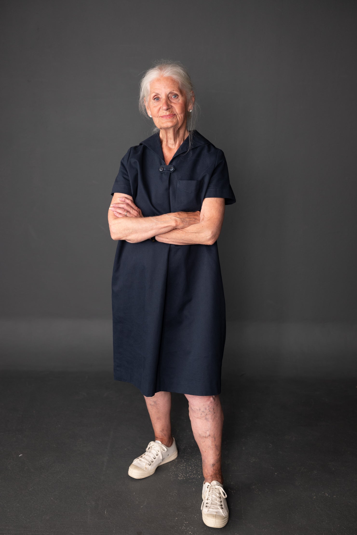 Woman wearing the Mary White Dress and Top sewing pattern by Merchant and Mills. A loose fitting dress pattern made in cotton twill, denim, linen or corduroy fabric featuring front and back pleats, side in-seam pockets, breast pocket and a sailor collar.