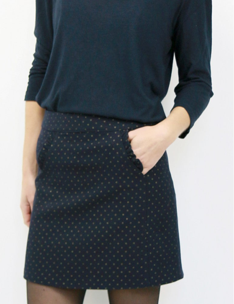 Woman wearing the Novembre Skirt sewing pattern by Atelier Scammit. A skirt pattern made in medium to heavy woollens or jacquard fabrics, featuring a short A-line style and in-seam pockets.