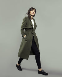 Woman wearing the Londres Trench Coat sewing pattern from Orageuse on The Fold Line. A trench coat pattern made in lyocell, viscose, microfiber or gabardine fabrics, featuring a tailored collar, wide lapels, asymmetrical shoulder flap and shoulder tabs, m