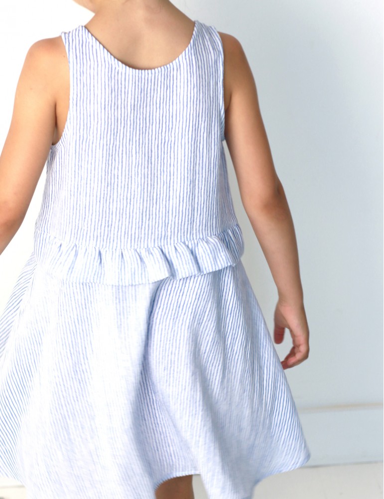 Child wearing the Baby/Child Petite Lune Dress sewing pattern by Atelier Scammit. A sleeveless dress pattern made in light to medium batiste, double gauze and light denim fabrics, featuring a full circle skirt and scooped necklines.