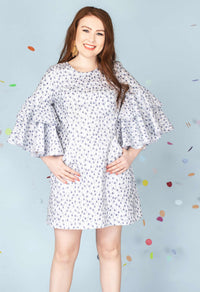 Woman wearing the Pina Colada Dress sewing pattern from Our Lady of Leisure on The Fold Line. A dress pattern made in broadcloth, lawn or chambray fabrics, featuring an A-line shape, mini length, double-layered flounce sleeves, princess seams with hidden 
