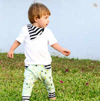 Child wearing the Child/Baby Pocket Joggers sewing pattern from Elemeno Patterns on The Fold Line. A joggers pattern made in stretch fabrics, featuring full length legs, deep ankle cuffs, deep waistband, front slash pockets and a roomy fit.