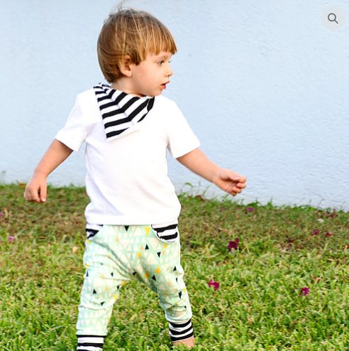 Child wearing the Child/Baby Pocket Joggers sewing pattern from Elemeno Patterns on The Fold Line. A joggers pattern made in stretch fabrics, featuring full length legs, deep ankle cuffs, deep waistband, front slash pockets and a roomy fit.