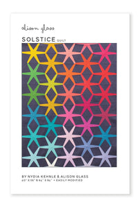 Photo showing the Solstice Quilt sewing pattern from Alison Glass on The Fold Line. A quilt pattern made in quilting cotton fabrics, featuring a hexagon and hexagram star pattern.