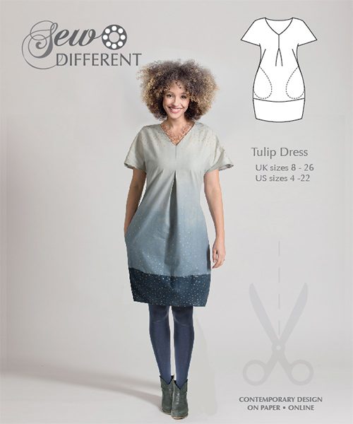 Woman wearing the Tulip Dress sewing pattern from Sew Different on The Fold Line. A dress pattern made in cotton, linen, denim, corduroy, wools or double knit fabrics, featuring a bubble hem, V-neck, front pleat, short swing sleeves, in-seam pockets, and 