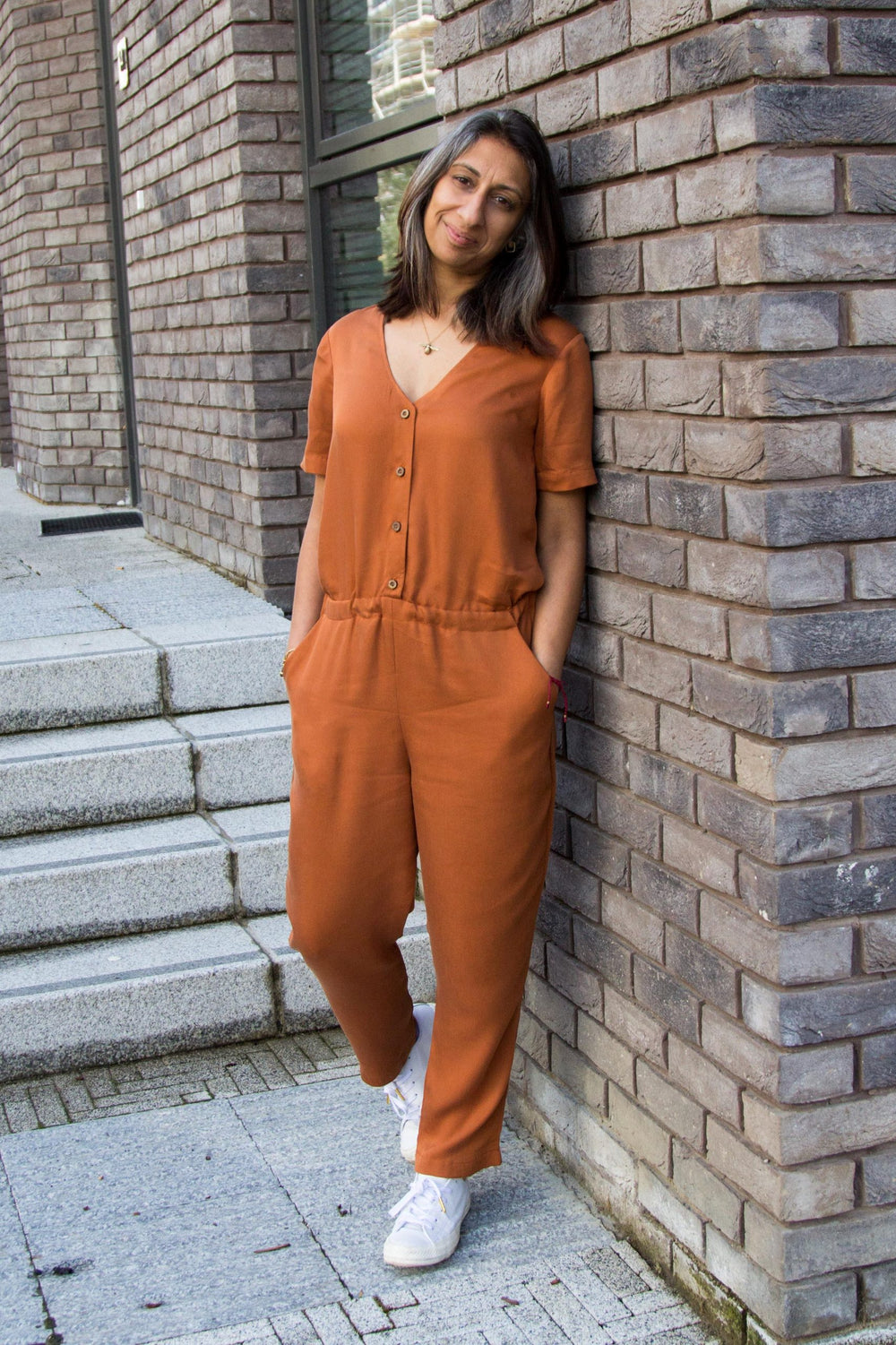 Woman wearing the Walla Jumpsuit sewing pattern from Make With Mandi on The Fold Line. A culottes/skirt pattern made in twill, viscose, linen, linen blends, chambray or lightweight stretch denim fabrics, featuring an elasticated waist, button front, relax