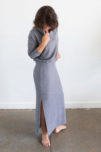 Woman wearing the Weaver Skirt sewing pattern from Allie Olson on The Fold Line. A skirt pattern made in knit fabric, featuring a fitted silhouette, hidden elastic waistband, double side slits, maxi length, and lining.