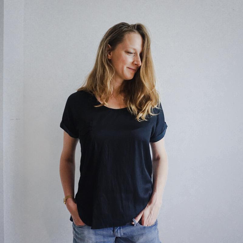 Woman wearing the Pocket T sewing pattern by Charlotte Kan. A T-shirt pattern made in silk, challis, voile, crepe, poplin, linen or double gauze fabrics, featuring a short cut-on sleeve with a turned up cuff, a relaxed fit and a small chest pocket.