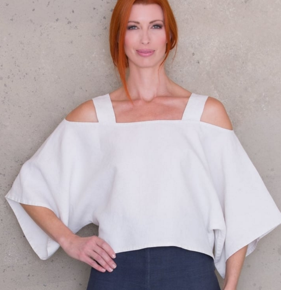 Woman wearing the Cold Shoulder Crop Top sewing pattern by Ann Normandy. A crop top pattern made in light to medium weight linen fabrics, featuring side vents, bell sleeves, square neckline and relaxed fit.