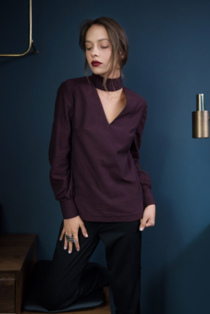 Woman wearing the Prague Blouse sewing pattern from Orageuse on The Fold Line. A blouse pattern made in viscose, cotton, silk or Tencel fabrics, featuring a high collar with back button fastening, cut out V-neck detail and long sleeves with button fastenings.