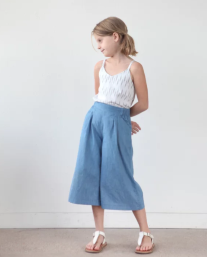 Girl wearing the Children’s Mini Emerson Crop Pant sewing pattern by True Bias. A trouser pattern made in cotton, linen, rayon challis or chambray fabric featuring an elasticated back and flat front waistband that sits just below the natural waist, front pleats and side pockets.