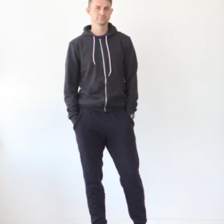 Man wearing the Men’s Hudson Pant sewing pattern by True Bias. A modern sweatpant pattern made in French terry, ponte or sweatshirt knit fabric featuring an elastic waist with drawstring, front pockets, a tapered leg with a cuff at the ankle.