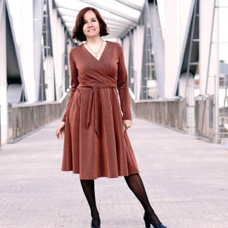 Woman wearing the Wanda Wrap Dress sewing pattern from Wardrobe by Me on The Fold Line. A wrap dress pattern made in light weight jersey fabrics, featuring a six-gore skirt, full length sleeves, V-neckline, and knee length hem.
