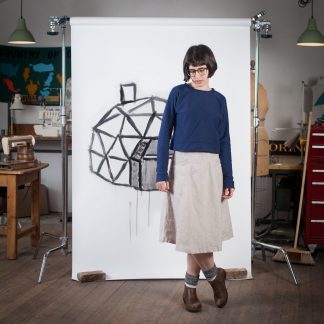 Woman wearing the Geodesic Top sewing pattern by Blue Prints for Sewing. A pullover top pattern made in light-medium weight knit fabrics, featuring long sleeves, round neck and waist length finish.