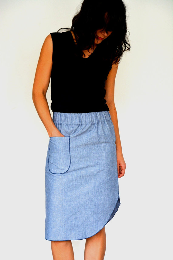 Woman wearing the Roma Midi Skirt pattern from Halfmoon Atelier on The Fold Line. A pencil skirt pattern made in light or medium weight denim or denim like fabrics, featuring an elastic waist, front patch pocket, knee length with rounded side slit.