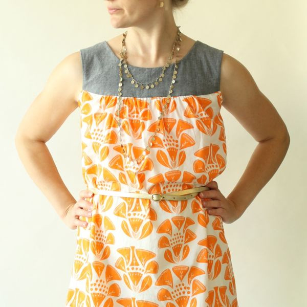 Woman wearing the Ruby Dress sewing pattern from Made by Rae on The Fold Line. A pullover, sleeveless dress pattern made in linen or rayon challis fabric, featuring a contrast yoke with gathers, round neck, optional belt and above knee length finish.