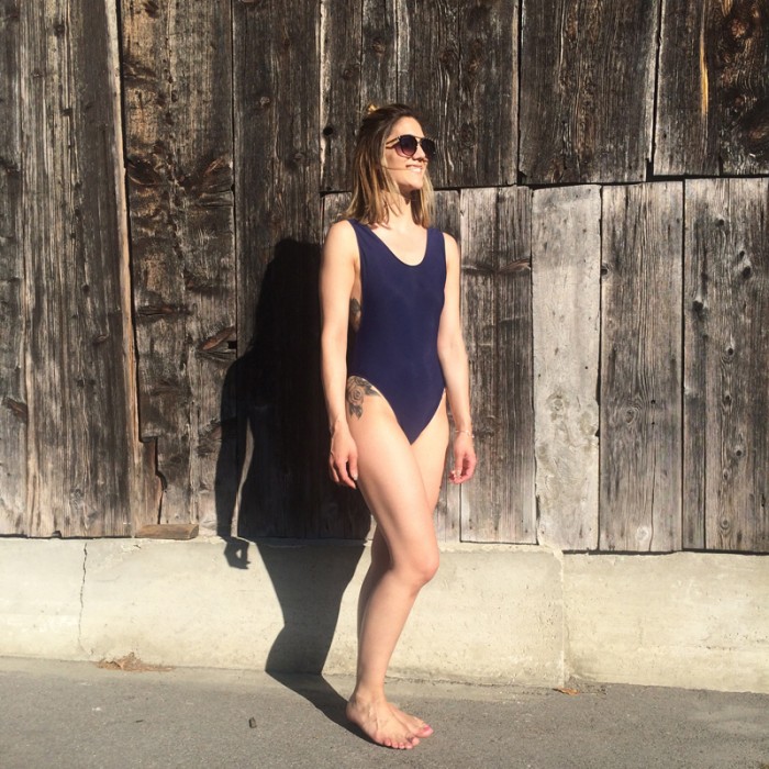 Woman wearing the Säntis Swimsuit sewing pattern from Opian on The Fold Line. A swimsuit pattern made in four-way stretch fabric in lycra, polyamide or nylon fabrics, featuring a low scoop back, low scoop armholes, medium scoop neckline and high rise leg.