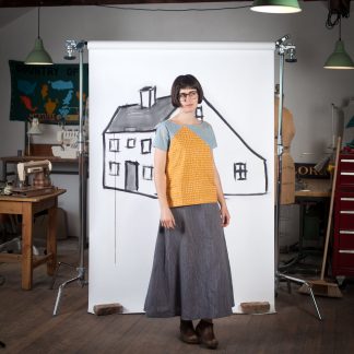Woman wearing the Saltbox Tee sewing pattern by Blue Prints for Sewing. A T-shirt pattern made in quilting cotton, chambray, linen blends, rayon challis, voile, lawn, double gauze, crepe de chine or charmeuse fabrics, featuring a short sleeves, boat neck and side vents at the hem.