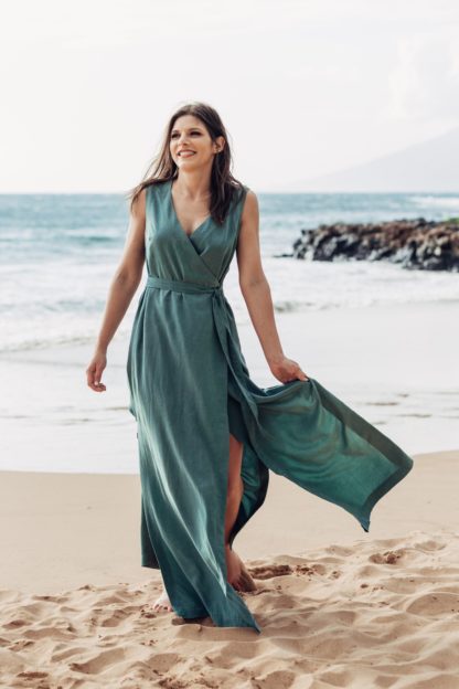 Woman wearing the Highlands Wrap Dress sewing pattern by Allie Olson. A sleeveless dress pattern made in mid- to lightweight woven fabrics such as rayon/linen blends, rayon challis, tencel, crepe de chine or georgette fabrics, featuring a V-neckline, elasticised back waistband, waist ties and a side slit that begins above the knee.