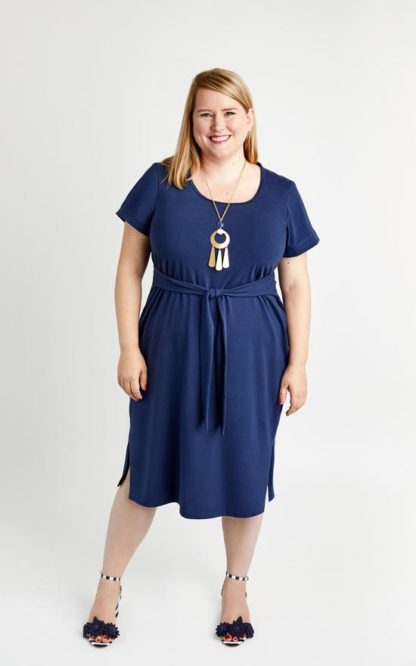 Woman wearing the Pembroke Dress sewing pattern by Cashmerette. A T-shirt dress pattern made in mid-weight knit fabric such as cotton/lycra, poly/lycra or rayon jersey fabric featuring a scoop neckline, side slits, short sleeves and a waist front tie.