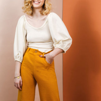 Woman wearing the Adrienne Blouse sewing pattern by Friday Pattern Company. A blouse pattern made in knits or jersey fabric featuring billowy statement sleeves that are gathered up at the shoulders and a medium low round neckline.