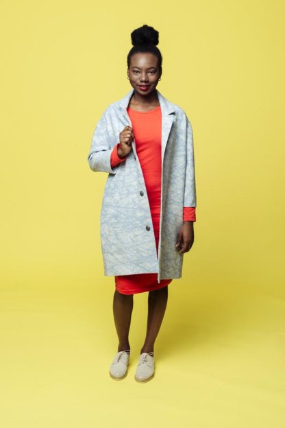 Woman wearing the Marte Coat sewing pattern from Melilot on The Fold Line. A coat pattern made in cotton, linen or wool fabrics, featuring an oversized fit, dropped shoulders, side seam pockets, three front button closure, ¾ length sleeve, flat collar and above knee length hem.