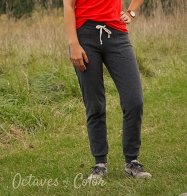 Woman wearing the Diane Joggers sewing pattern from 5 out of 4 Patterns on The Fold Line. A joggers pattern made in mid to heavy weight knit fabric with at least 40% 2-way stretch such as ponte, french terry, stretch sweatshirt fleece and heavier weight cotton Lycra fabrics, featuring a slim fit through the hip and waist and looser knee and calf, higher back rise and curved yoke, elasticated waist with drawstring, cuffed ankle and front patched pockets.