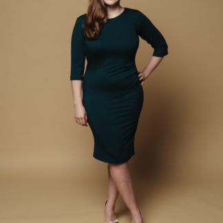 Woman wearing the Runa Dress sewing pattern from Melilot on The Fold Line. A dress pattern made in jersey fabrics, featuring asymmetric pleats on the side of the front waist, full length sleeves, scoop neckline and knee length finish.