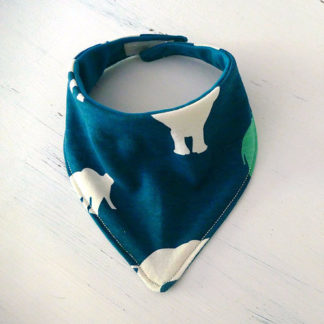 Image showing the Child/Baby Bandana Bib sewing pattern from Elemeno Patterns on The Fold Line. A bandana bid pattern made in knit or woven fabrics, featuring a triangular reversible bib with Velcro, button or snap closure.