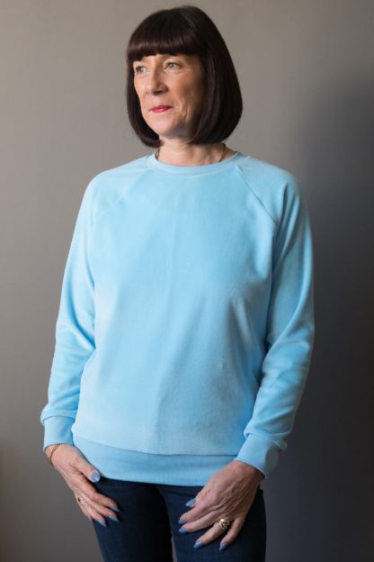 Woman wearing the Lynn Sweatshirt sewing pattern by Bobbins and Buttons. A sweatshirt pattern made in sweatshirt fabrics, stable knits, stretch velvet or lighter weight jersey fabrics, featuring a long raglan sleeve and rib trim on the neck, cuff and hem bands.