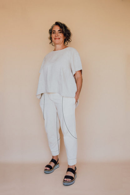 Woman wearing the Darlow Pants pattern from In the Folds on The Fold Line. A trouser pattern made in linen, linen blends, cotton drill/twill, denim, wool or silk fabrics, featuring a cropped length, tapered leg, fly front with zip closure, shaped waistband, in-seam pockets and back pockets.