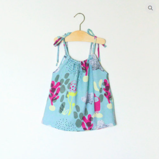 Image showing the Baby/Child Cami Dress sewing pattern from Elemeno Patterns on The Fold Line. A dress pattern made in lightweight woven or knit fabrics, featuring adjustable shoulder straps, gathered front and back neckline, no sleeves and a loose fit.