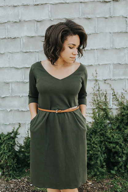 Woman wearing the Meridan Knit Dress sewing pattern from Sew To Grow on The Fold Line. A dress pattern made in jersey knit, double knit or ITY fabrics, featuring a V-neckline, ¾ length sleeves, slash pockets, gathered skirt and above knee length.