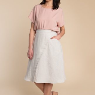 Woman wearing the Fiore Skirt sewing pattern by Closet Core Patterns. An asymmetrical wrap skirt pattern made in linen, chambray, denim or poplin fabric featuring a high waist, and single hip pocket.