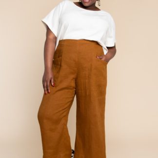 Woman wearing the Pietra Pants sewing pattern by Closet Core Patterns. A trouser pattern made in linen, chambray, lightweight denim or twill fabric featuring a flat front, high waist with elastic at the back and slanted hip pockets.